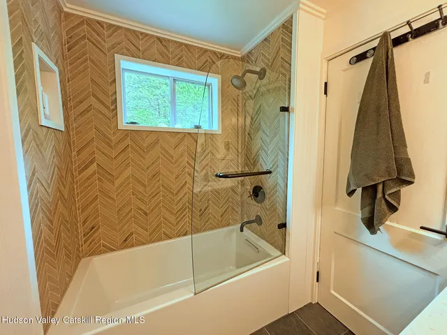 a bathroom with a tub a sink and a window