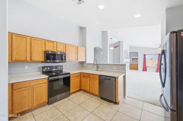 a kitchen with stainless steel appliances granite countertop a stove a sink and a refrigerator