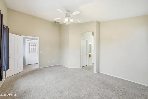 a view of an empty room with a chandelier fan