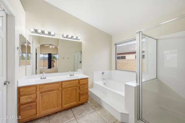 a spacious bathroom with a tub sink shower and mirror