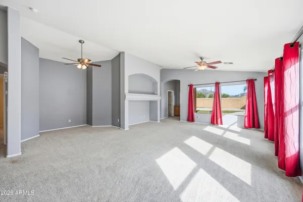 a view of an empty room with a fireplace and a chandelier