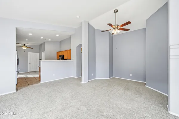 an empty room with a ceiling fan and a window
