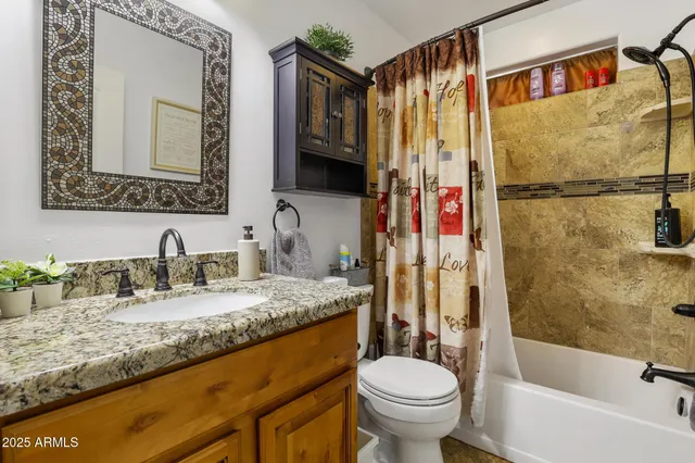 a bathroom with a granite countertop sink toilet and shower