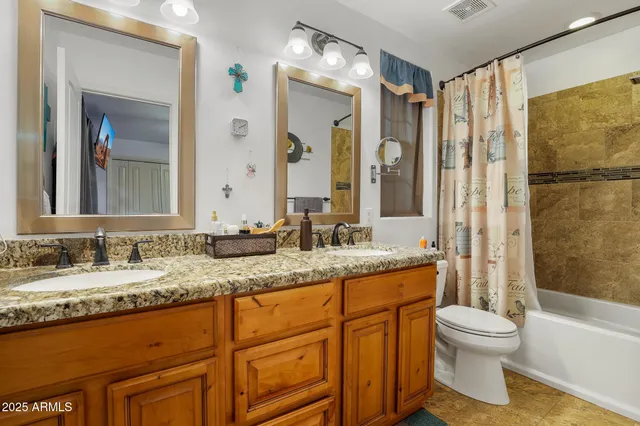 a bathroom with a granite countertop sink toilet mirror and bathtub