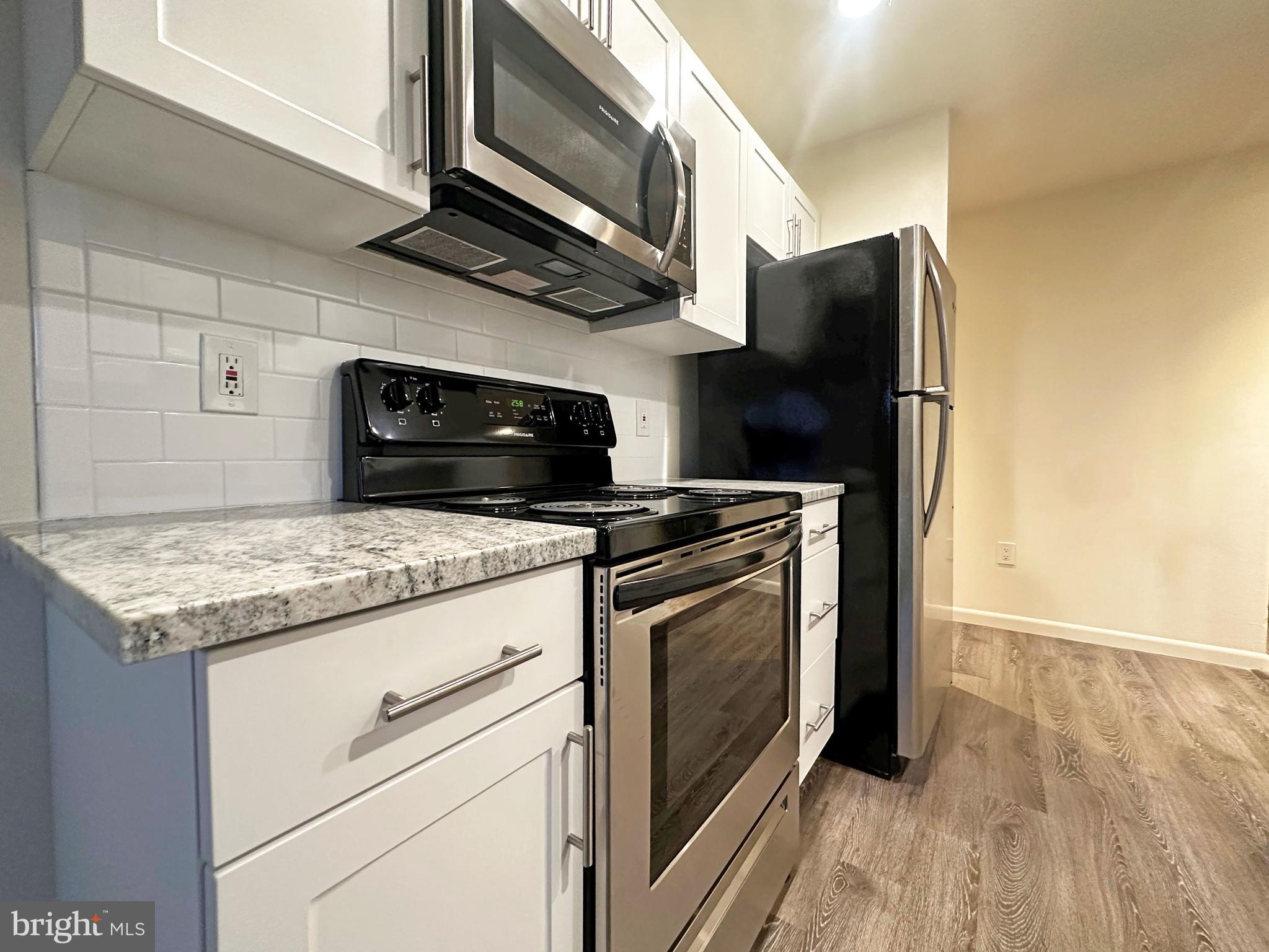 200 Spruce Street, Unit C8 Doylestown, PA 18901 - Photo 3 of 11 a kitchen with stainless steel appliances granite countertop a stove microwave and refrigerator