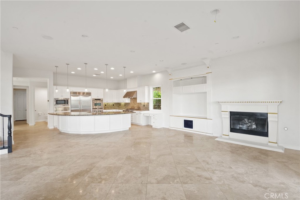 4925 Lone Acres Court Rancho Cucamonga, CA 91737 - Photo 17 of 68 a large white kitchen with a fireplace and a counter top space