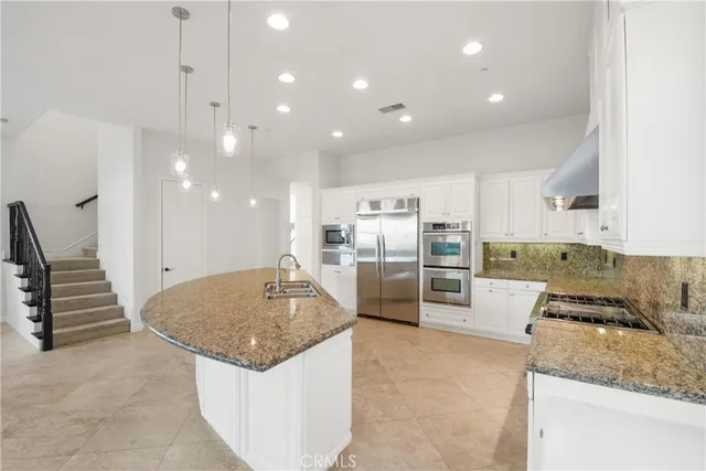 a bathroom with a granite countertop sink and a toilet