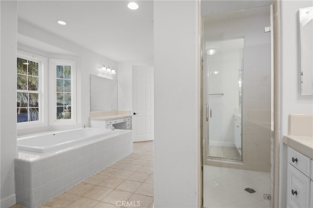 4925 Lone Acres Court Rancho Cucamonga, CA 91737 - Photo 45 of 68 a large white bathroom with a tub shower and sink