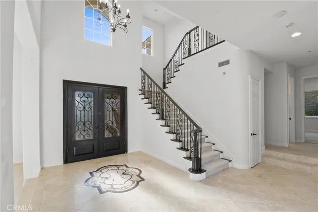 a view of a hallway with wooden floor and a chandelier