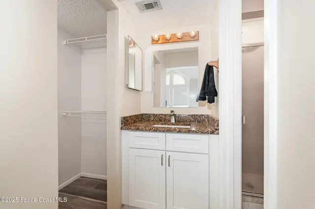 a bathroom with a granite countertop sink and a mirror