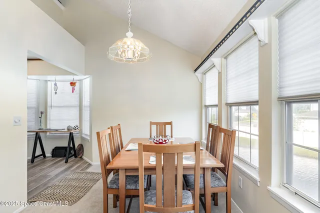 a view of a dining room with furniture a chandelier and wooden floor