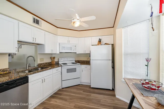 a kitchen with a sink a refrigerator and cabinets