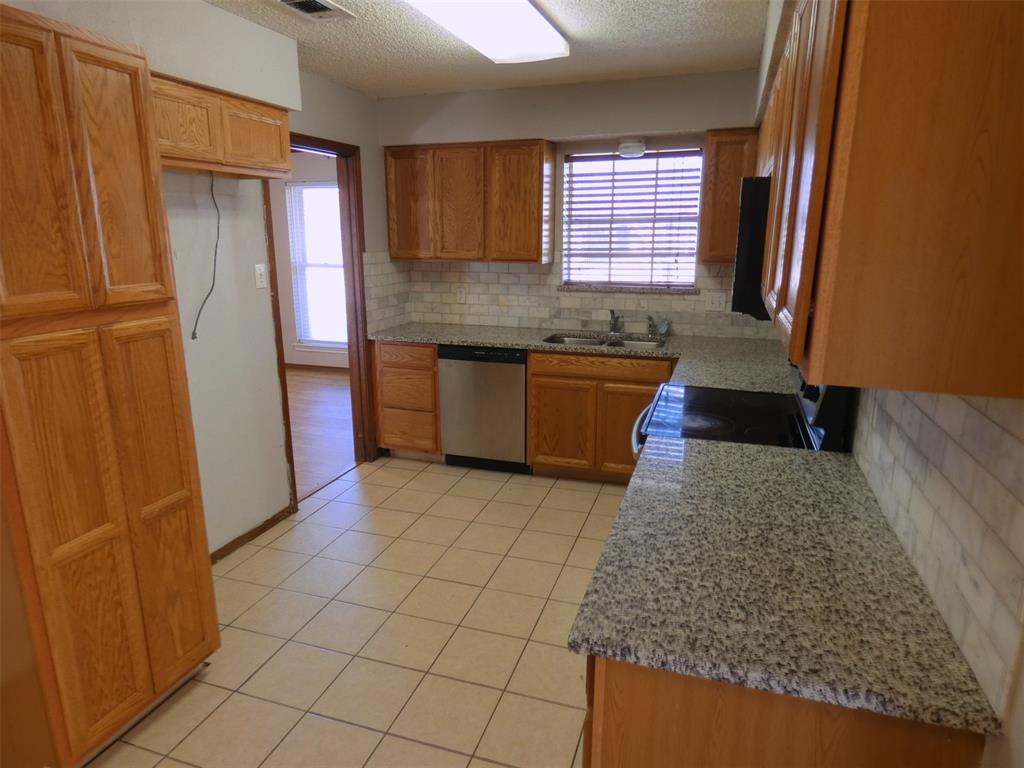 7110 Ridgeview Drive Rowlett, TX 75089 - Photo 11 of 27 a kitchen with granite countertop a refrigerator and a sink
