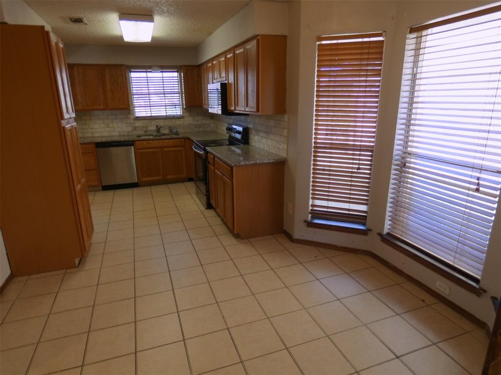 7110 Ridgeview Drive Rowlett, TX 75089 - Photo 12 of 27 a kitchen with stainless steel appliances a sink a stove a refrigerator and cabinets