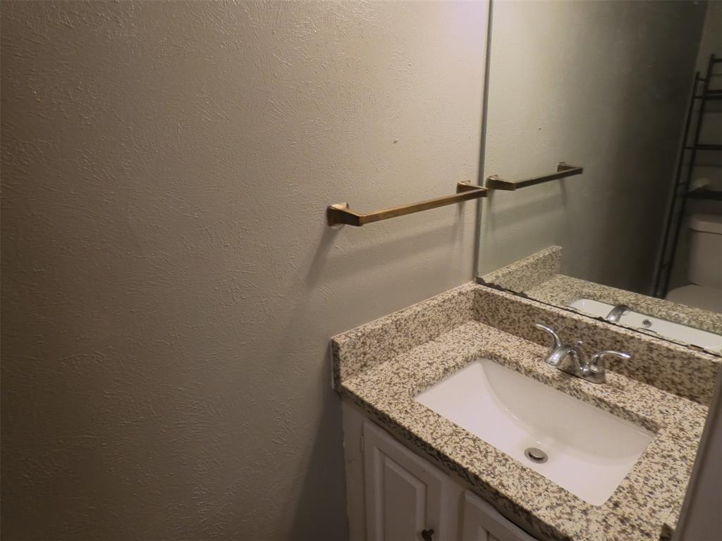 7110 Ridgeview Drive Rowlett, TX 75089 - Photo 14 of 27 a bathroom with a granite countertop sink and a mirror