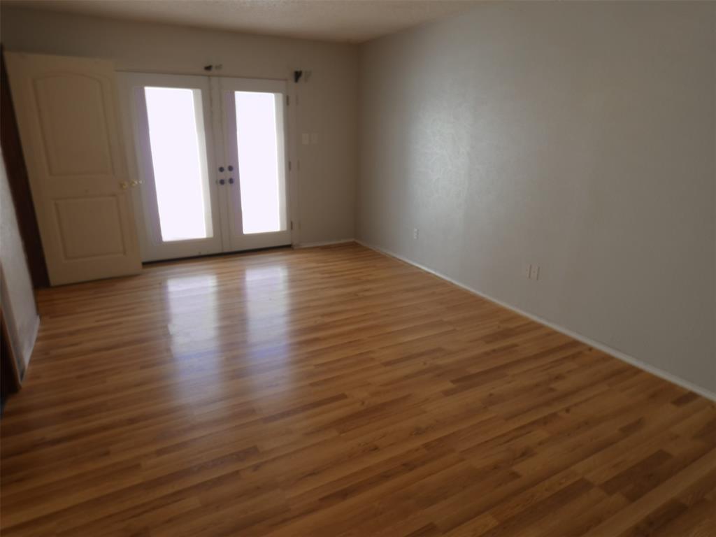 7110 Ridgeview Drive Rowlett, TX 75089 - Photo 17 of 27 an empty room with wooden floor and windows