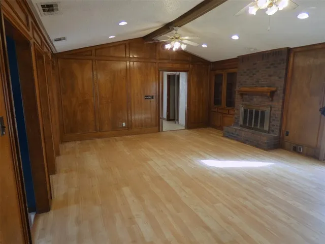 a view of empty room with wooden floor and fireplace