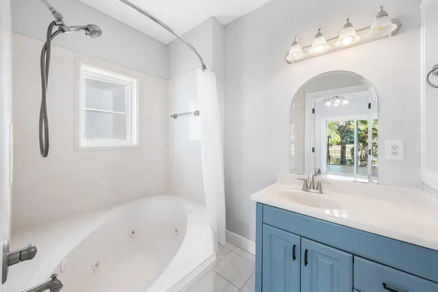 a bathroom with a tub sink and mirror