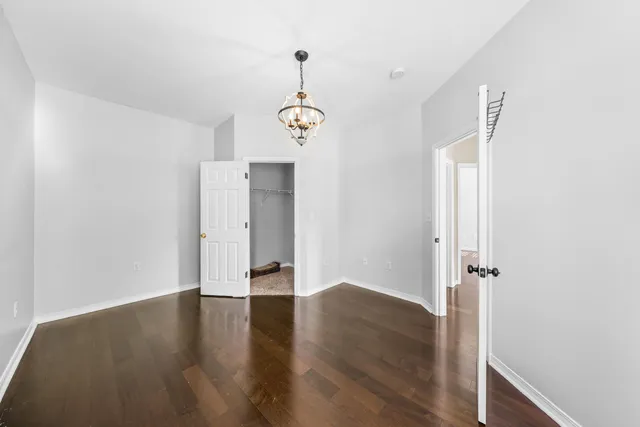 an empty room with wooden floor and ceiling fan