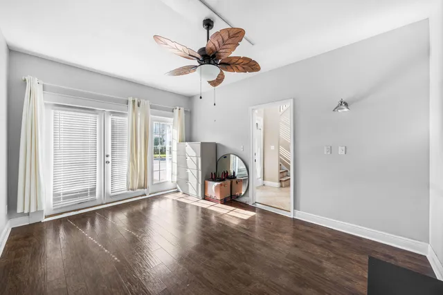 a view of a livingroom with wooden floor and a ceiling fan