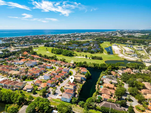 an aerial view of residential houses with outdoor space and trees