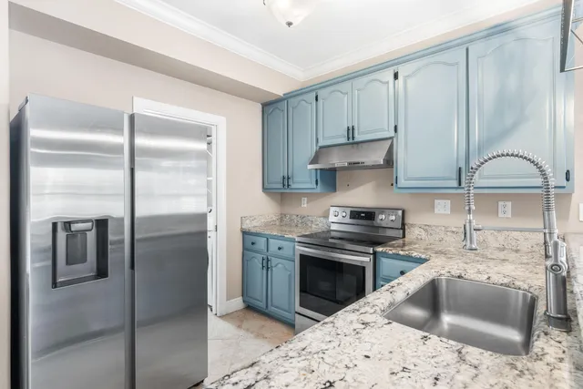 a kitchen with stainless steel appliances granite countertop a refrigerator sink and stove
