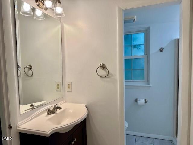 1208 Manassas Court, Unit A Raleigh, NC 27609 - Photo 12 of 16 a bathroom with a sink vanity and a mirror
