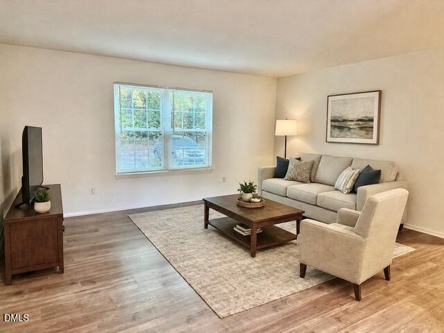 1208 Manassas Court, Unit A Raleigh, NC 27609 - Photo 3 of 16 a living room with furniture and a flat screen tv with wooden floor