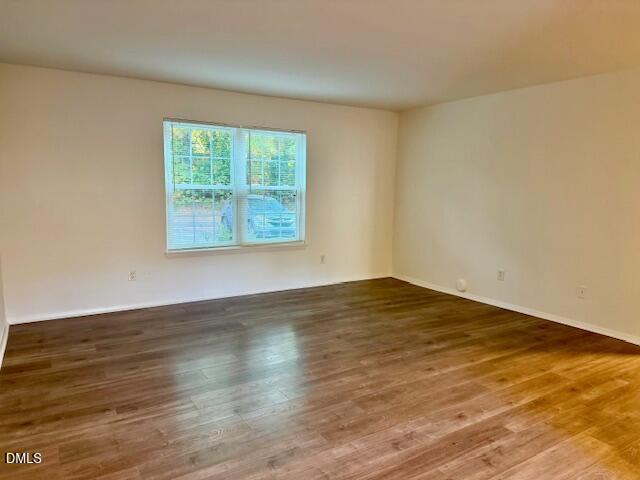 1208 Manassas Court, Unit A Raleigh, NC 27609 - Photo 4 of 16 a view of an empty room with wooden floor and a window