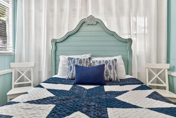 a bedroom with a bed and painting on the wall