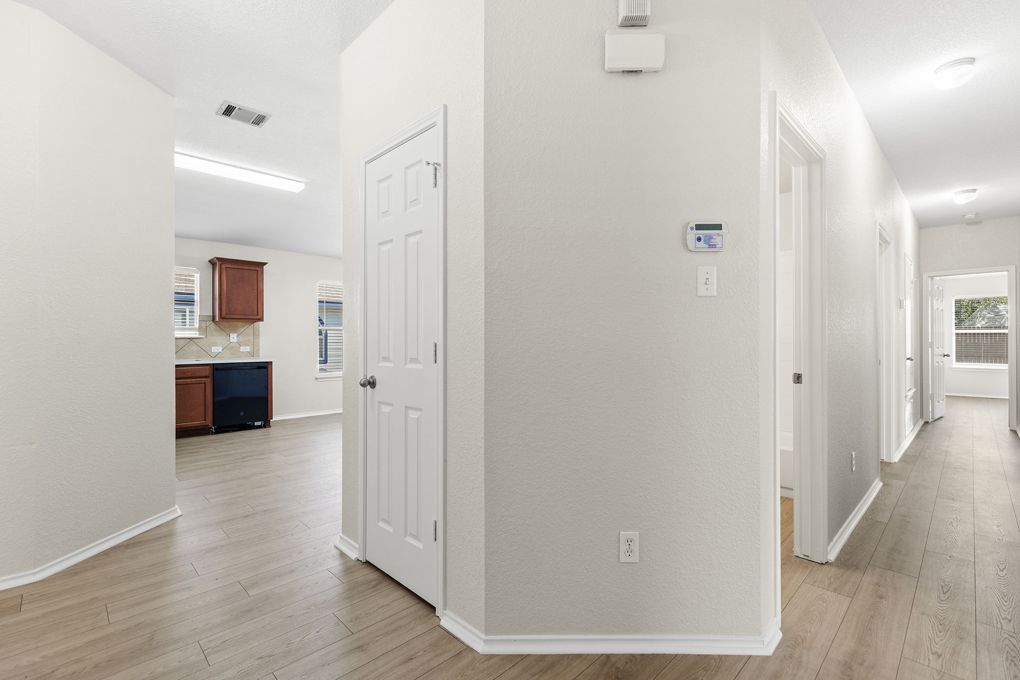 335 Altamont Street Hutto, TX 78634 - Photo 23 of 40 a view of a hallway with wooden floor and cabinet and a living room