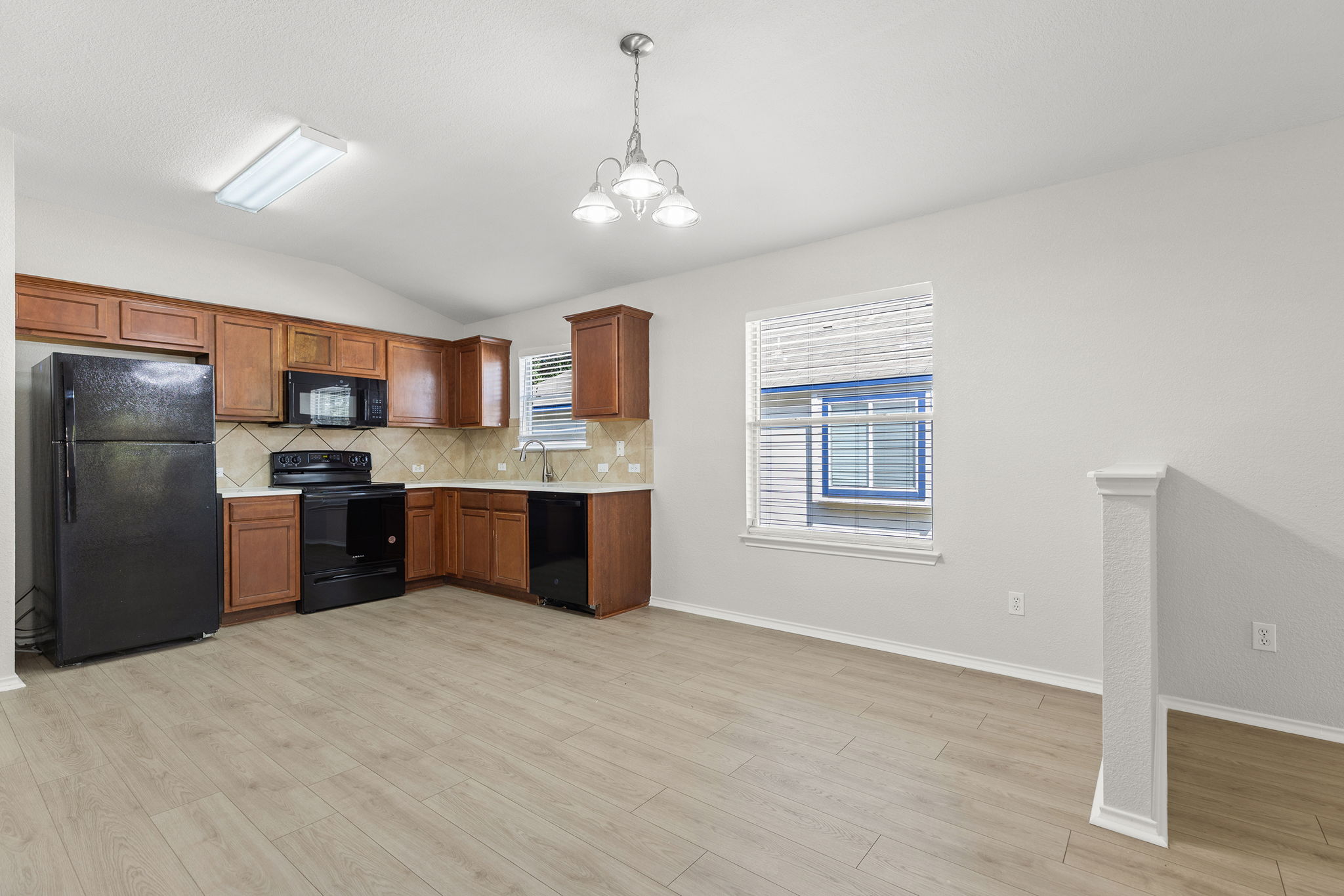 335 Altamont Street Hutto, TX 78634 - Photo 6 of 40 a large kitchen with stainless steel appliances granite countertop a sink refrigerator and cabinets
