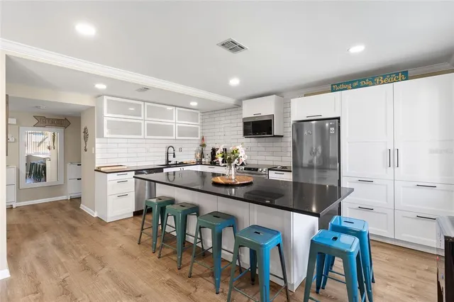 a kitchen with white cabinets and stainless steel appliances