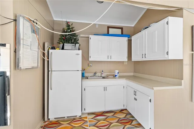a kitchen with refrigerator and cabinets