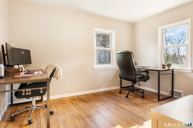 a kitchen with a sink and a stove with white cabinets