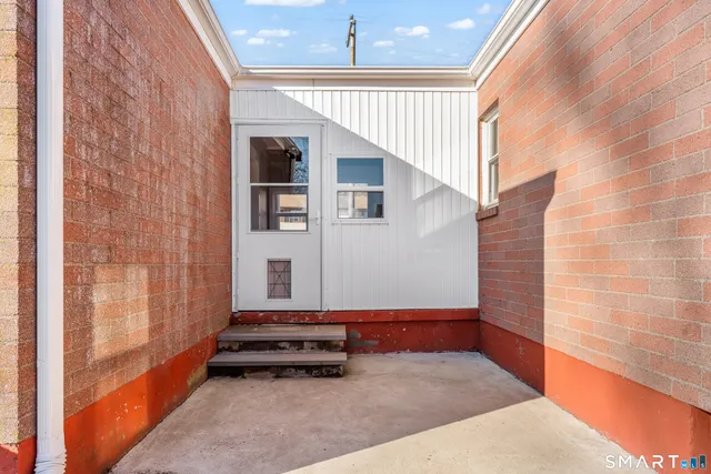 a view of a backyard with couches plants and large umbrella
