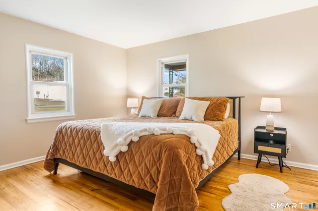 a bedroom with a bed and a lamp next to a window