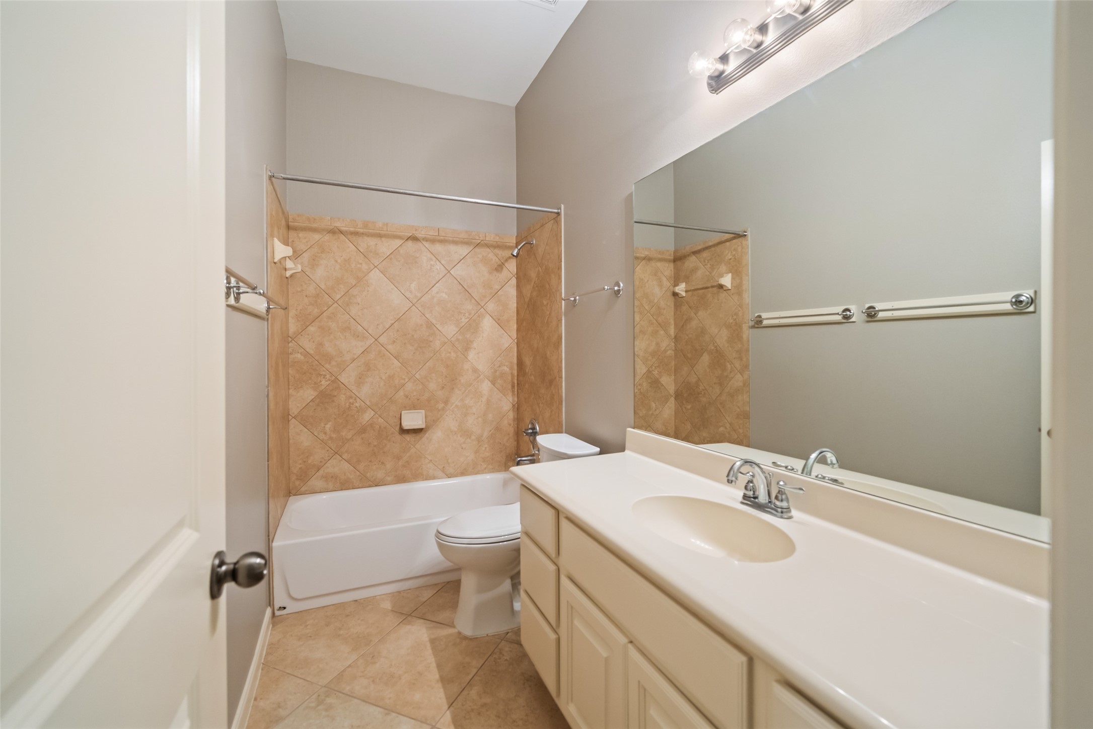 2818 Red Maple Drive Katy, TX 77494 - Photo 16 of 50 Secondary bathroom features a modern design with a neutral color palette, a single vanity with ample counter space, a large mirror, and a shower-tub combo with tiled walls.