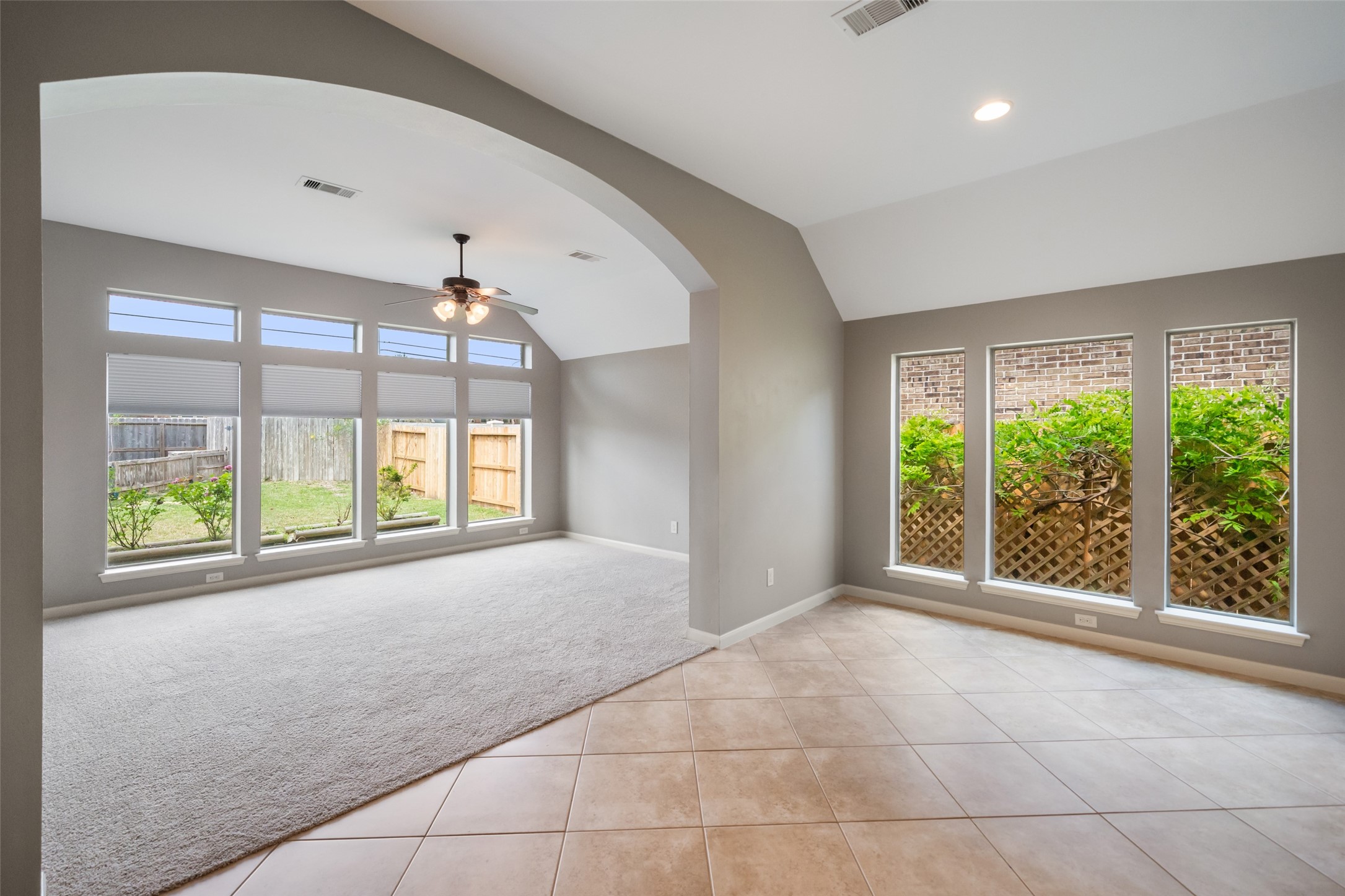 2818 Red Maple Drive Katy, TX 77494 - Photo 28 of 50 Game Room / Sun Room with large windows offering garden views. It features a new carpet and archway detail, and a ceiling fan for comfort.