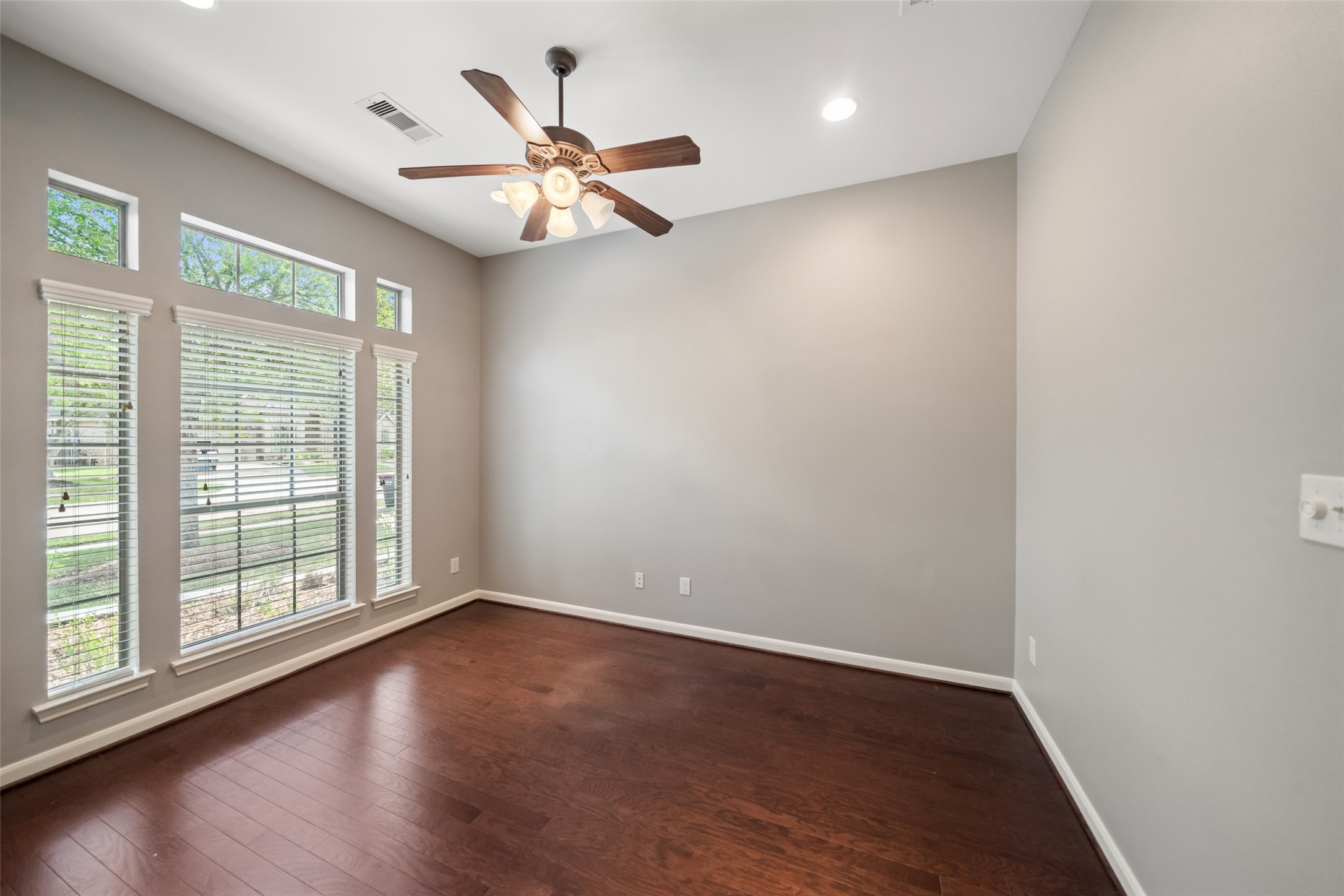 2818 Red Maple Drive Katy, TX 77494 - Photo 6 of 50 Study with hardwood floors, large windows with blinds for ample natural light, and a ceiling fan with lights, creating a bright and welcoming work space.