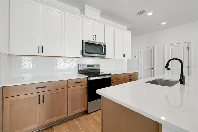 a kitchen with stainless steel appliances granite countertop white cabinets a sink and dishwasher