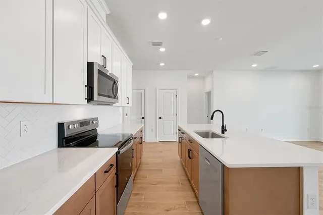 a kitchen with a sink a stove and cabinets