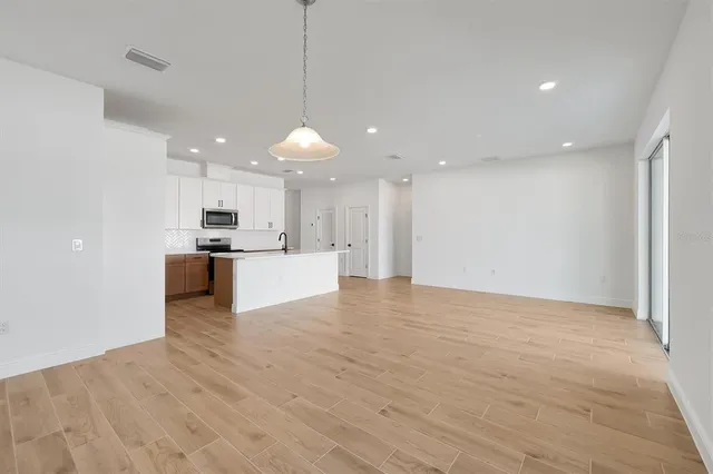 a view of kitchen with stove and cabinets