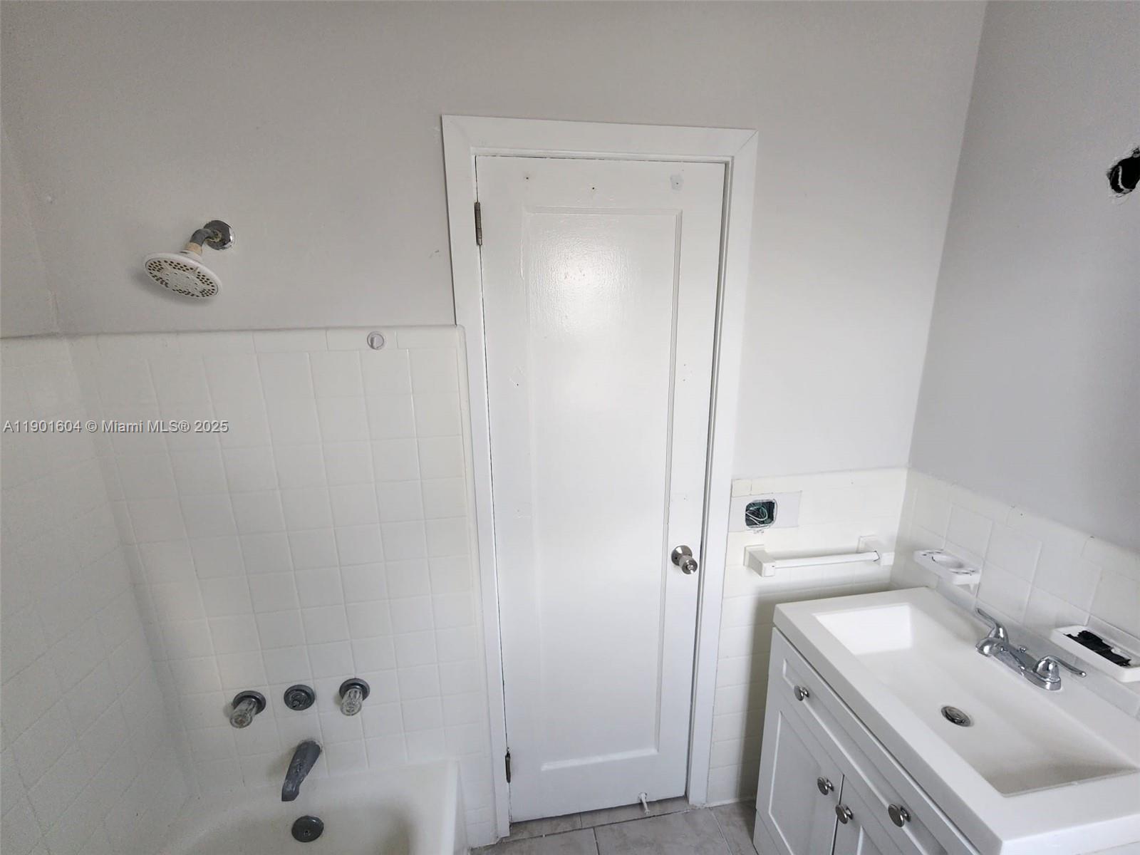 7611 Harding Avenue, Unit 9 Miami Beach, FL 33141 - Photo 7 of 15 a bathroom with a tub sink vanity and mirror