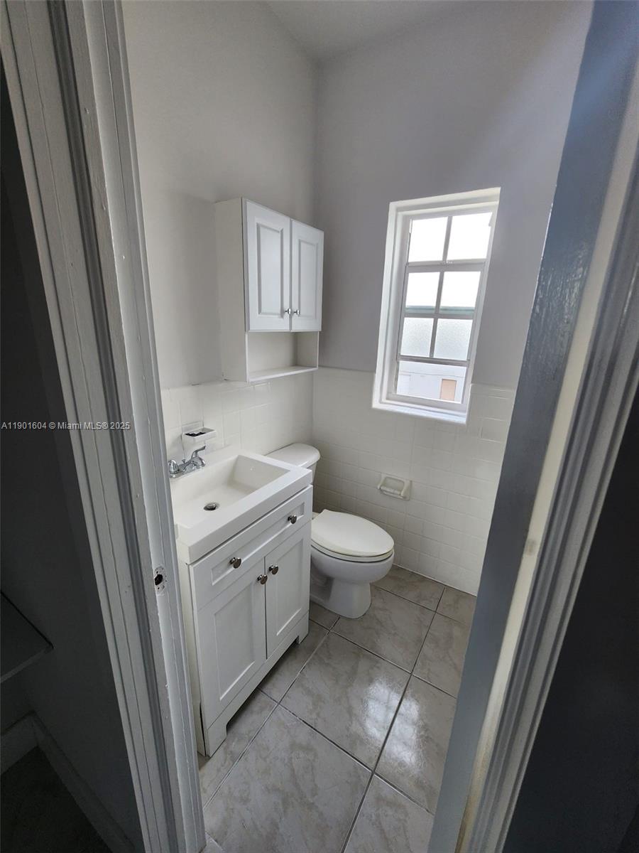 7611 Harding Avenue, Unit 9 Miami Beach, FL 33141 - Photo 8 of 15 a bathroom with a toilet sink and mirror