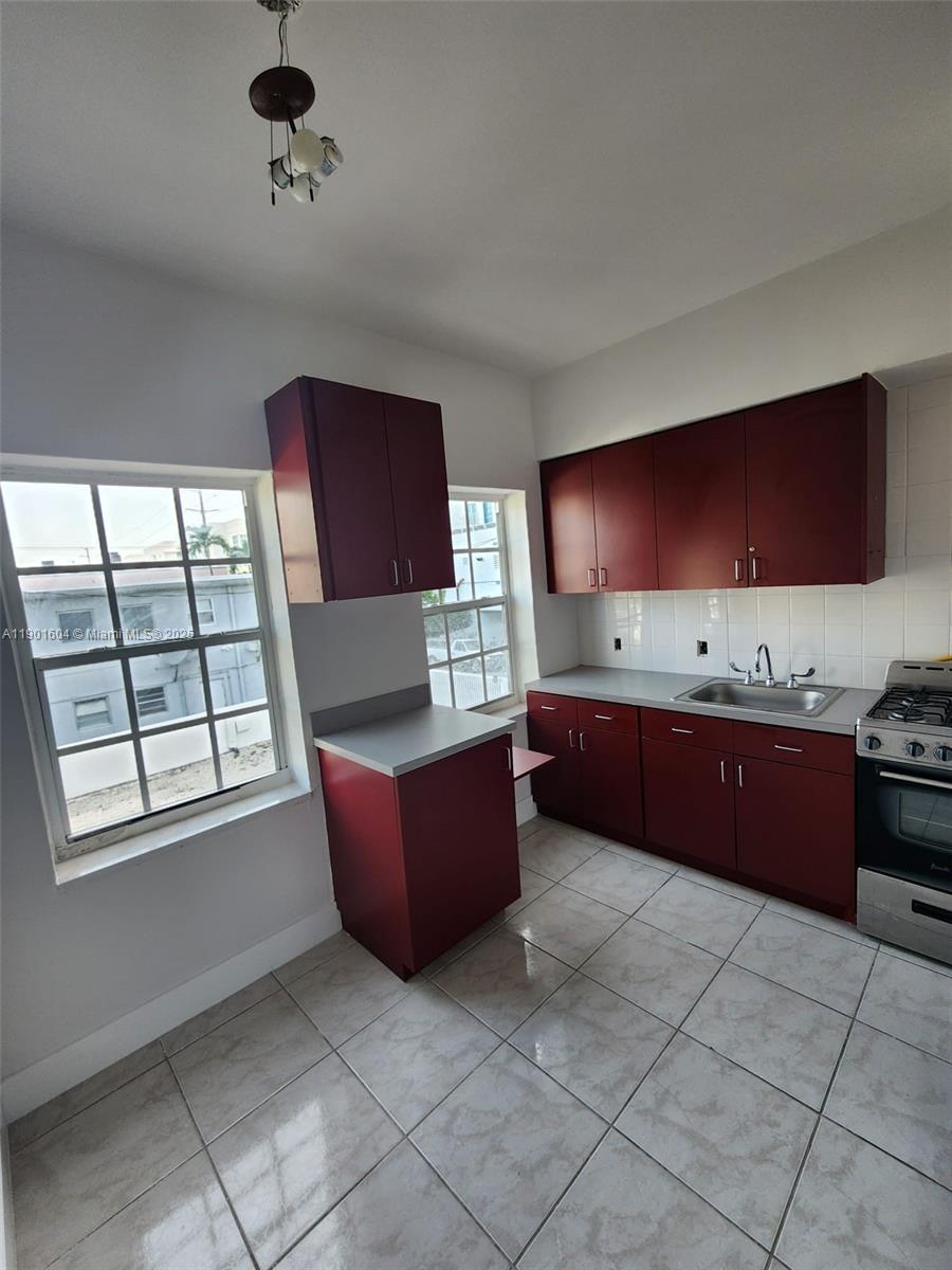 7611 Harding Avenue, Unit 9 Miami Beach, FL 33141 - Photo 9 of 15 a kitchen with stainless steel appliances granite countertop a stove a sink and a microwave