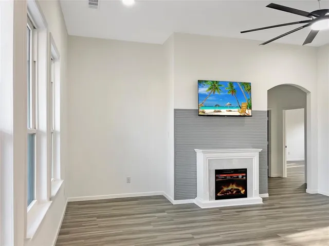 a view of a livingroom with wooden floor and a fireplace