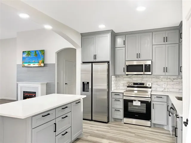 a kitchen with cabinets stainless steel appliances and a counter top space