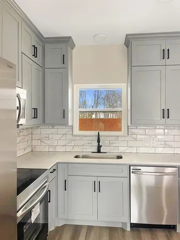 a kitchen with stainless steel appliances granite countertop a sink and a stove