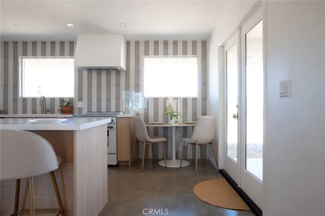 a room with a table chairs and a window